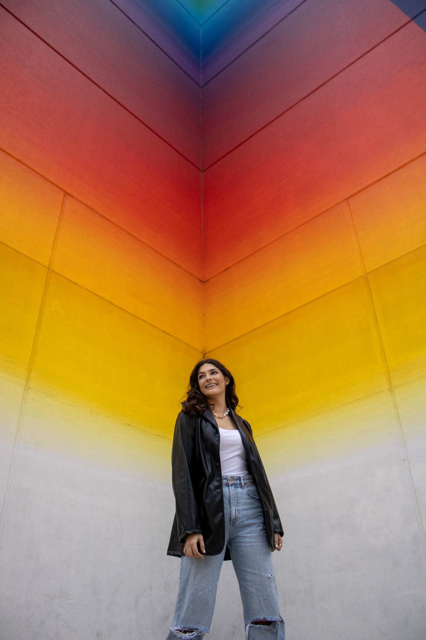 College student posing in front of the rainbow-colored Tau Ceti artwork in downtown Austin
