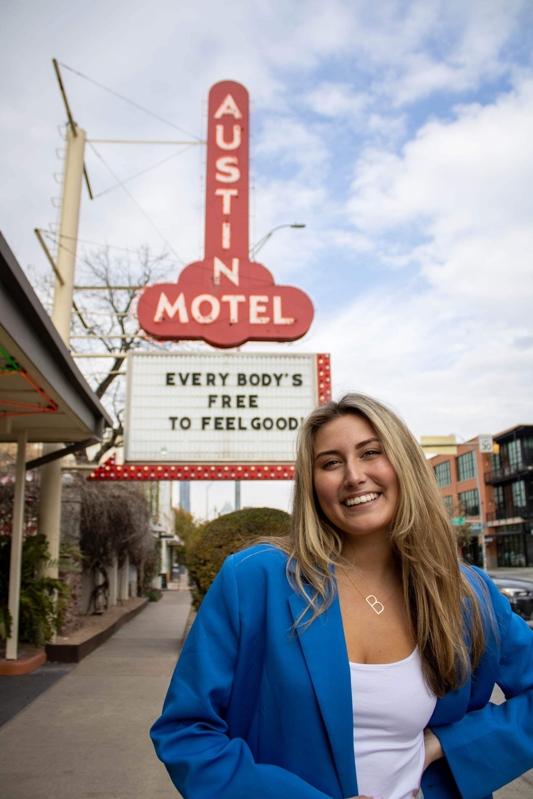 College student smiling in front of the famous Austin Motel sign on South Congress