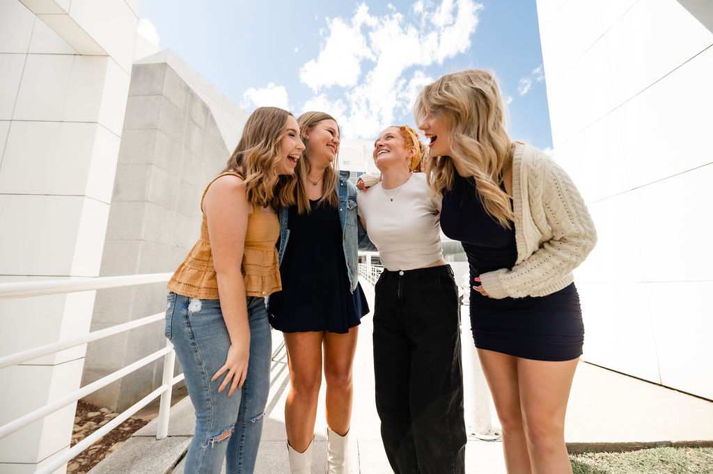 Four roommates laughing together outside