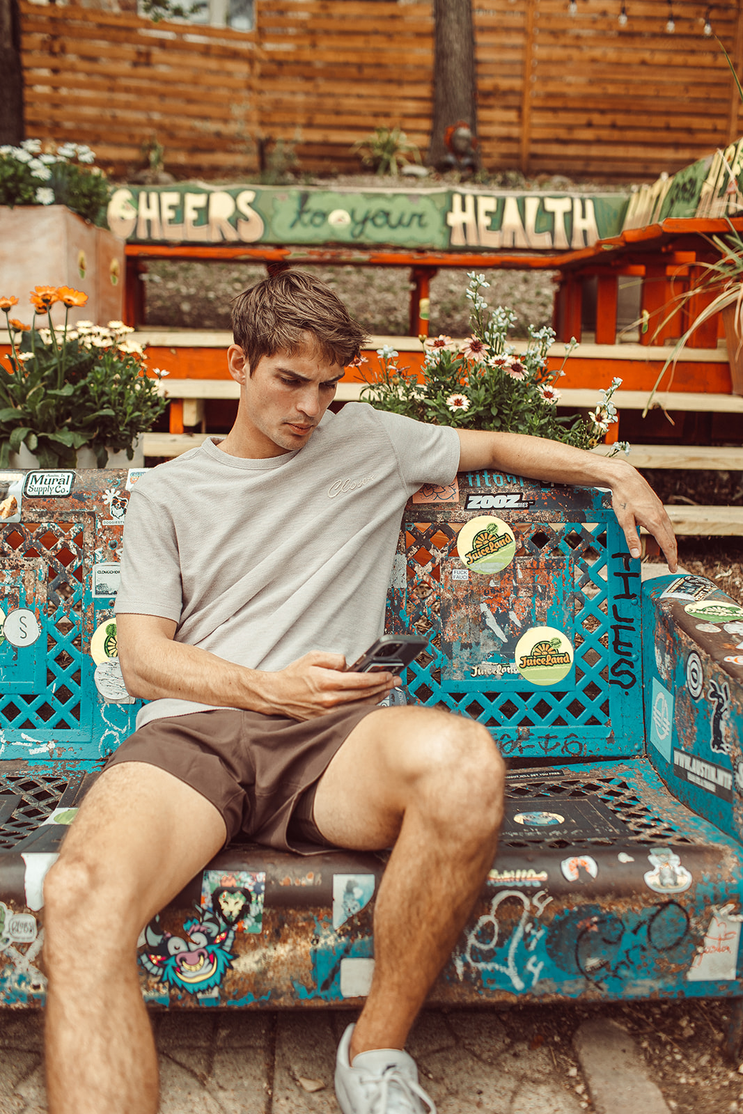 A UT student sits outside a JuiceLand in Austin scrolling through his phone