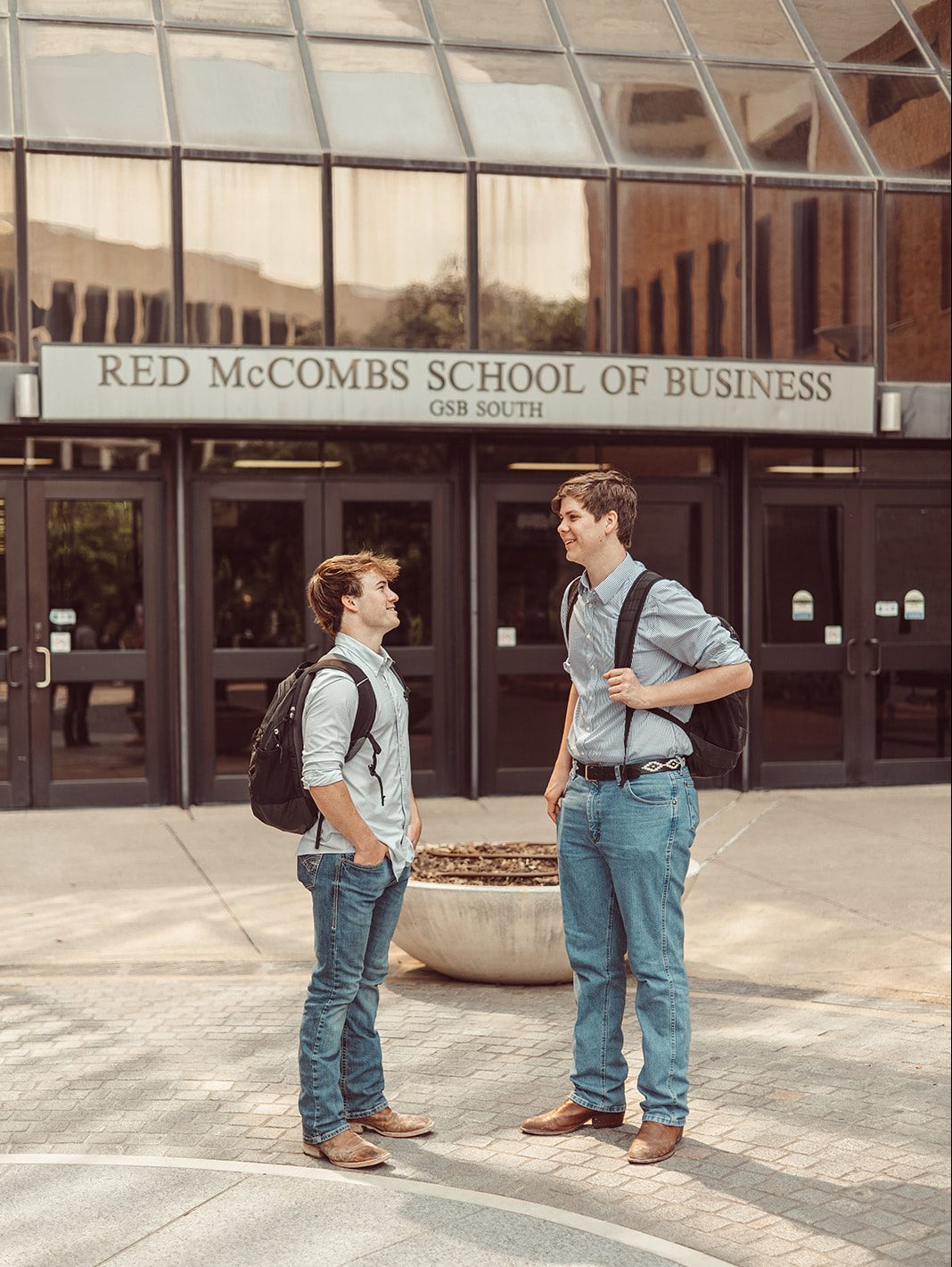 Two guys catch up after class outside the McCombs School of Business