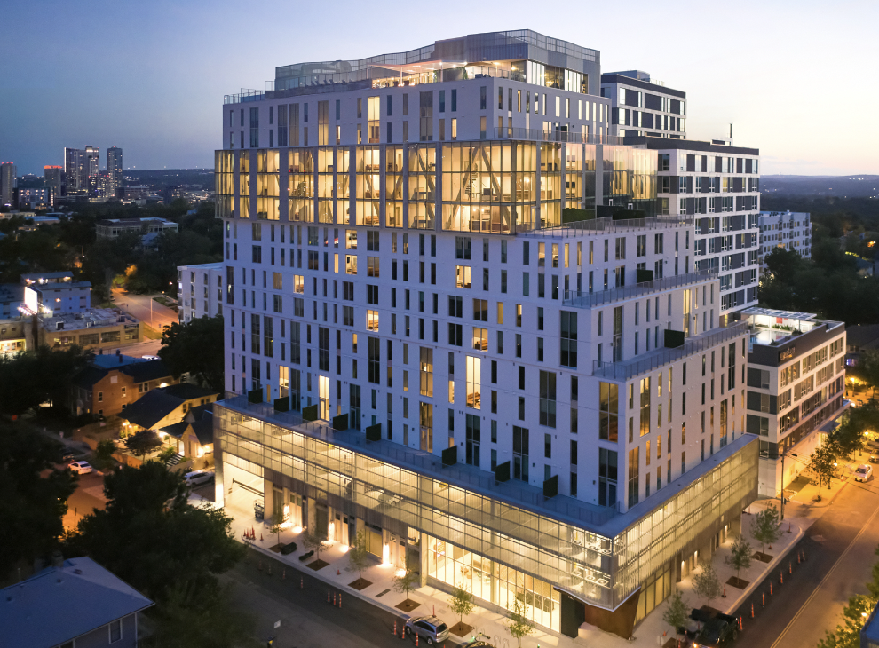 Building exterior of Torre, a student housing apartment in West Campus Austin, at night.