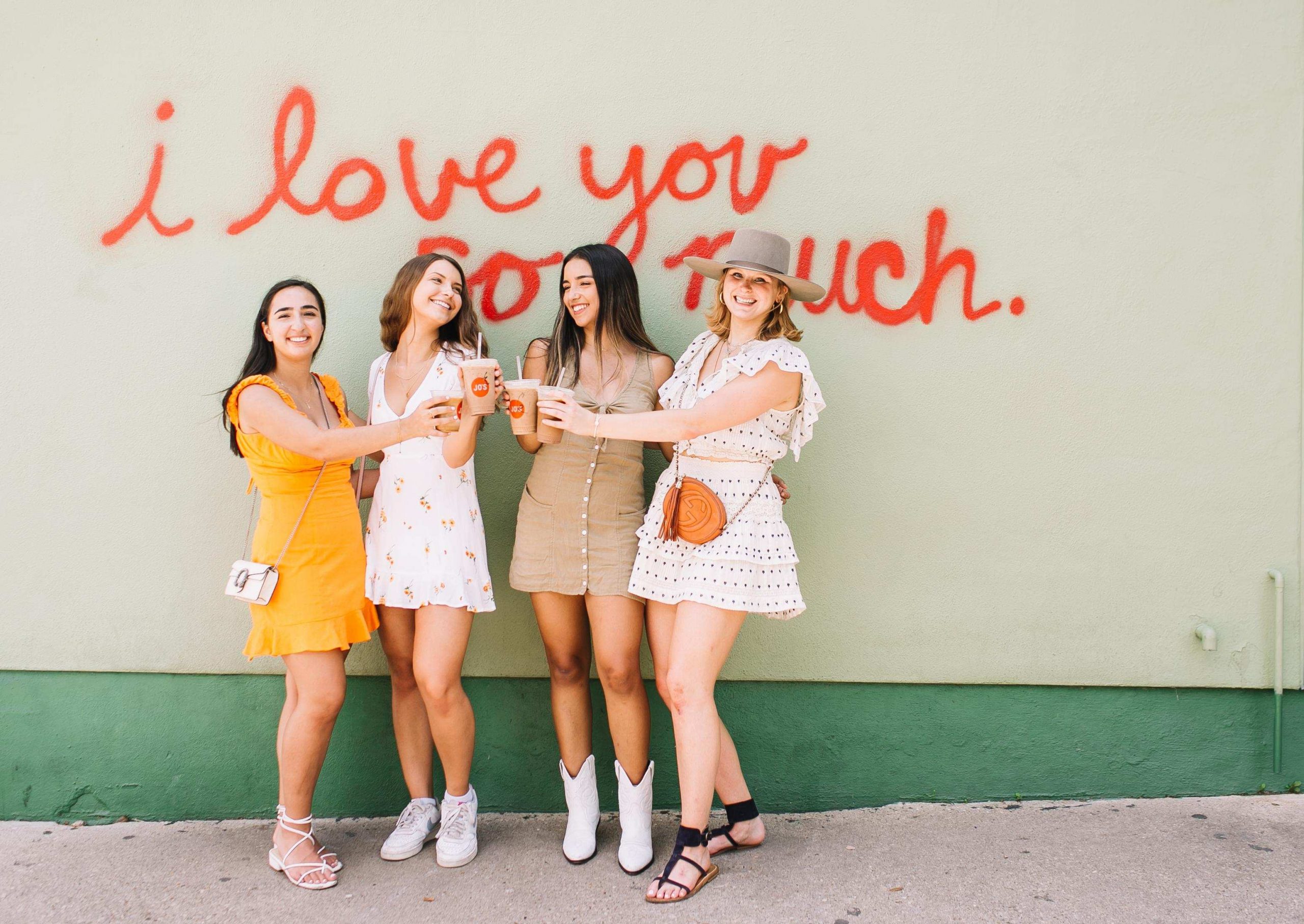 Girls at Jo's Coffee next to the I Love You So Much wall in Austin, Texas on South Congress.