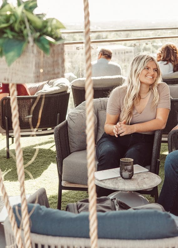 Friends talking at Otopia Rooftop happy hour in Austin, TX.