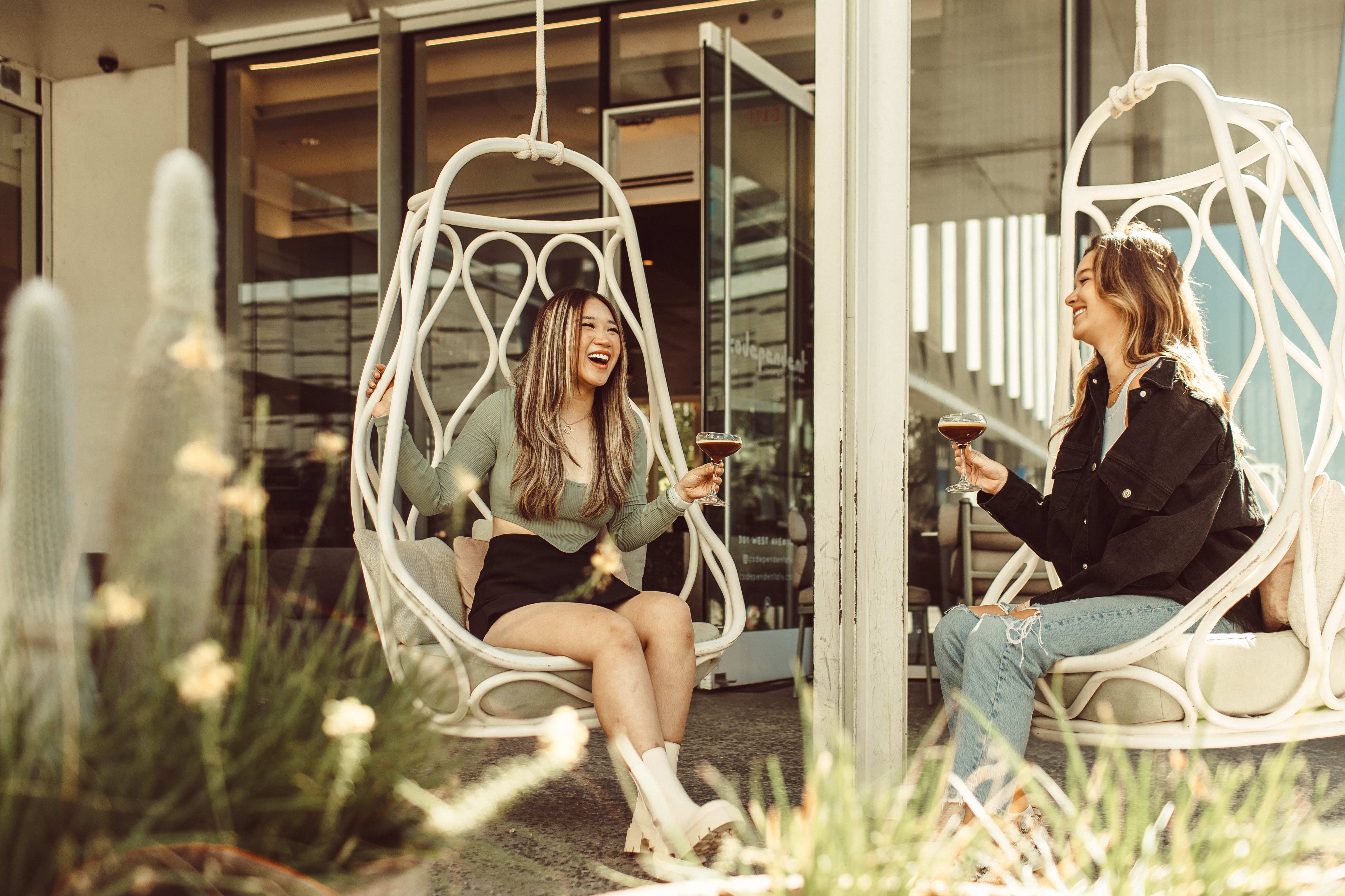 two UT austin students laughing on the patio at codependent coffee and cocktails