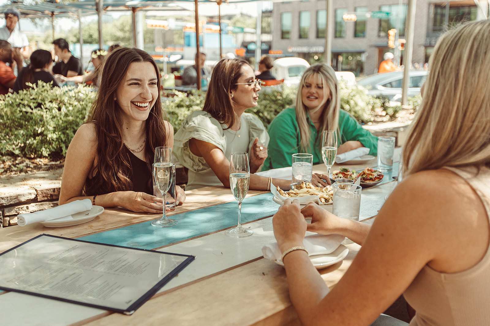 four new roommates laughing together at a picnic table in Austin, Texas