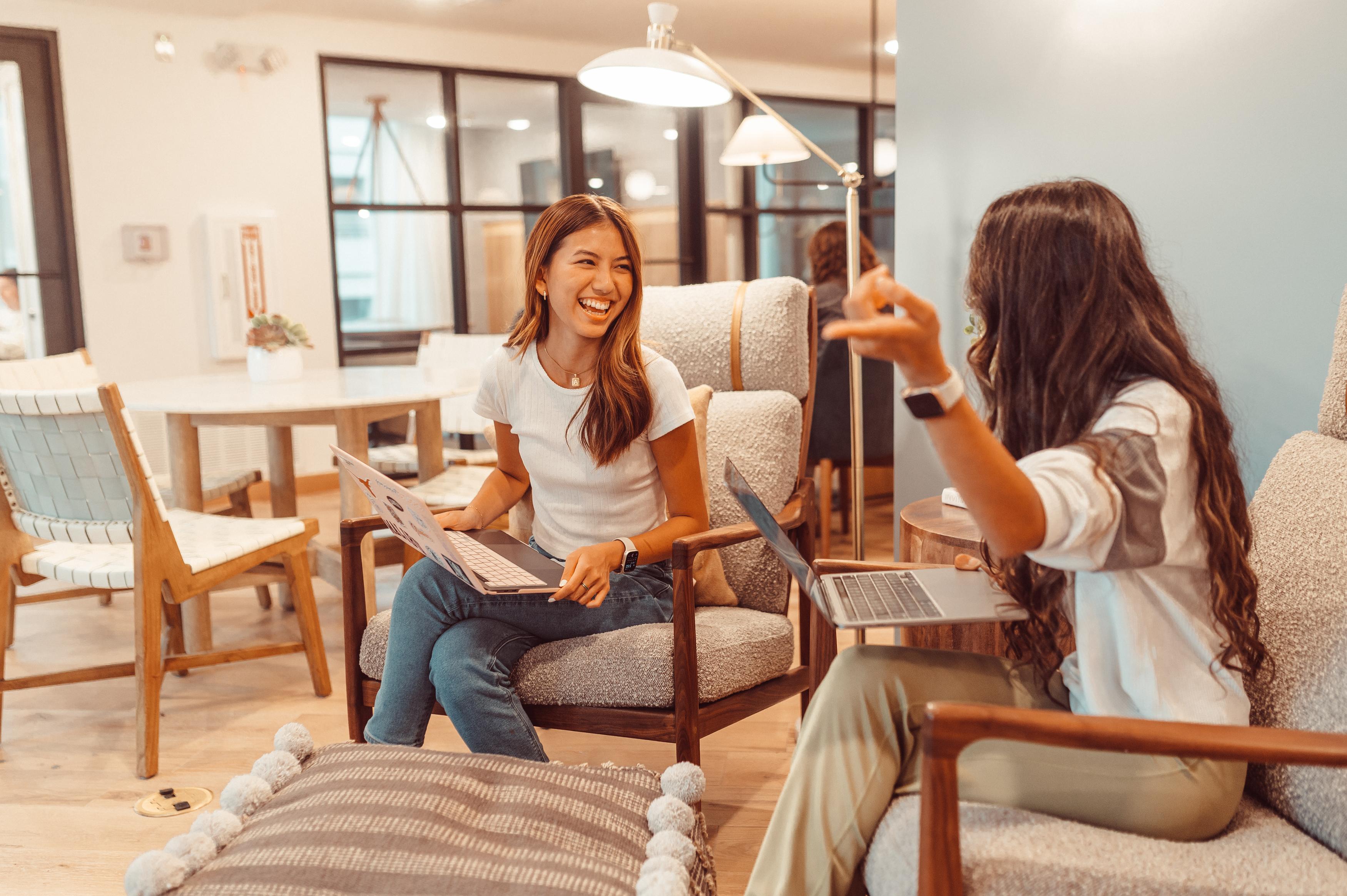 Two residents sharing a computer in the study space at Rambler Austin. 