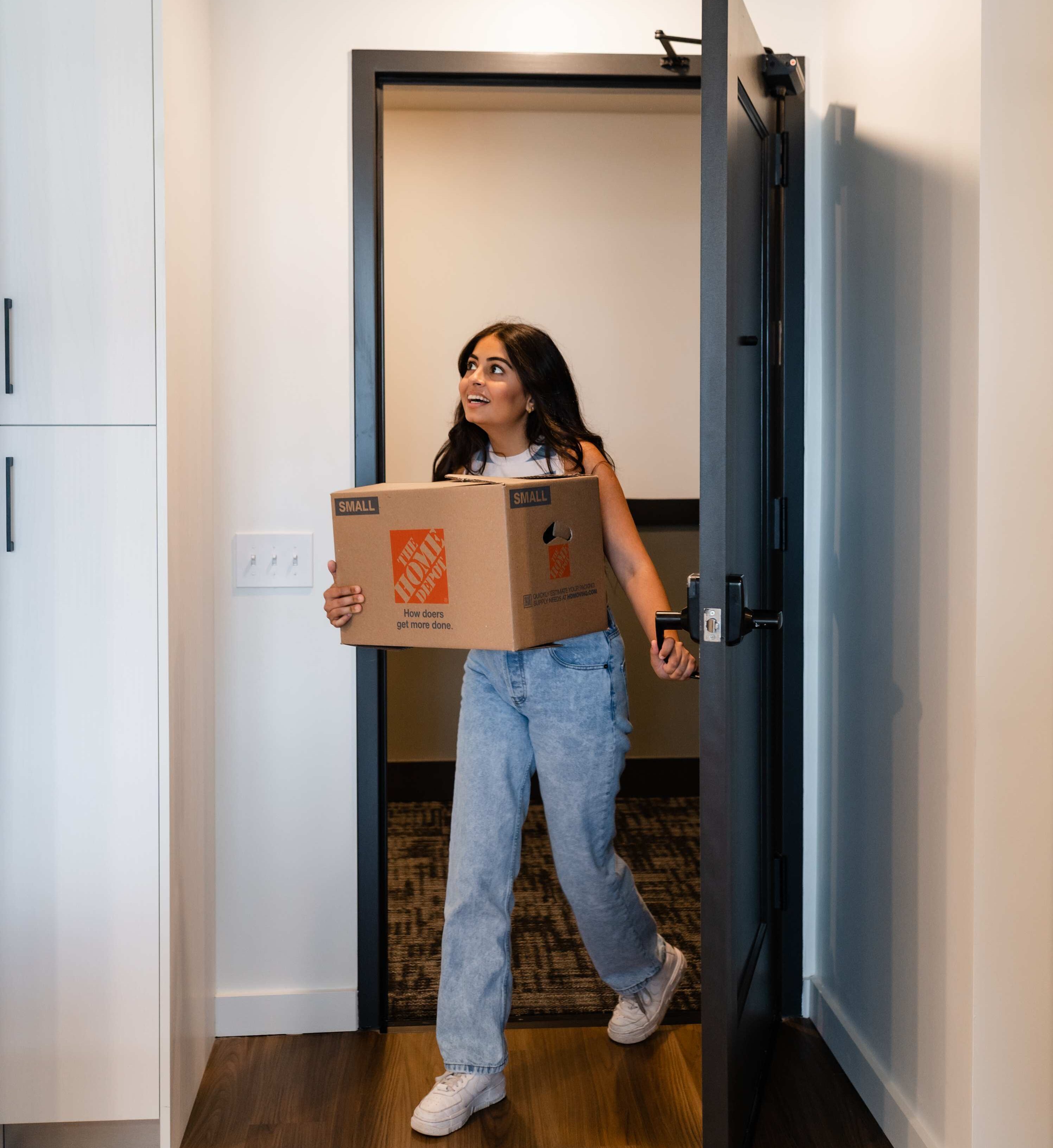 Girl carrying a box into her apartment